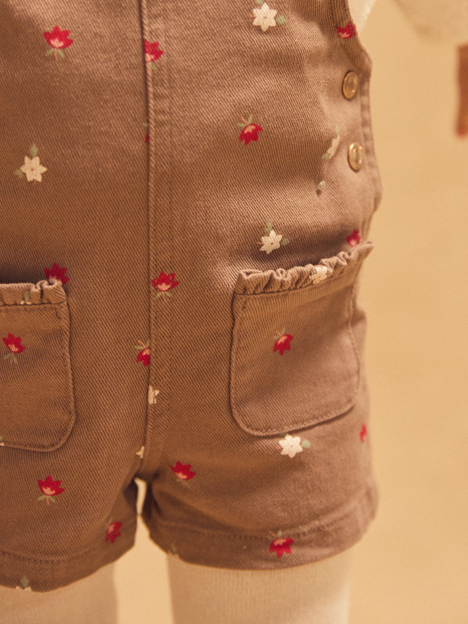 Salopette corta marrone con stampa floreale per bambina