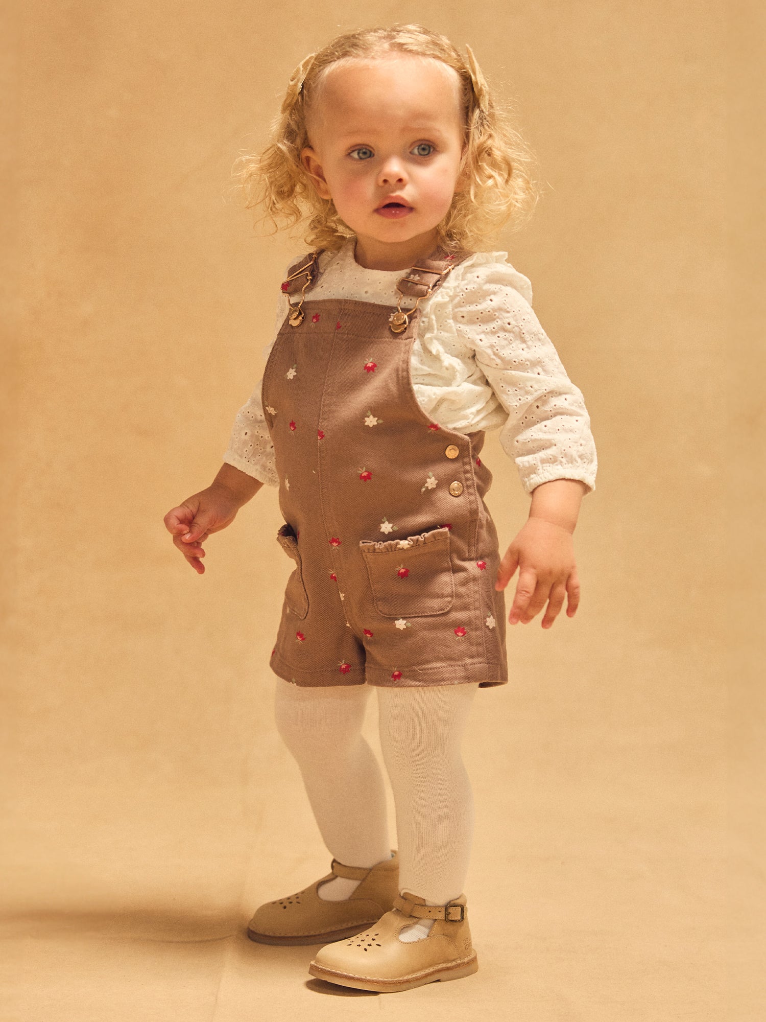 Salopette corta marrone con stampa floreale per bambina